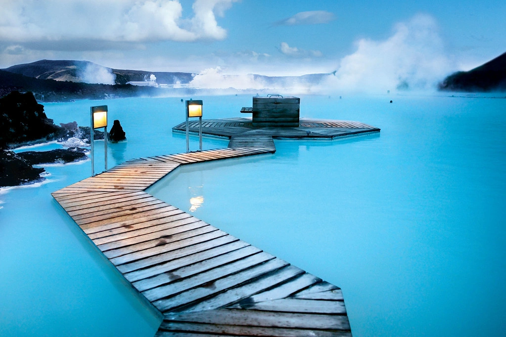 Blue Lagoon in Iceland, surrounded by volcanic landscapes and steaming, milky-blue geothermal waters.