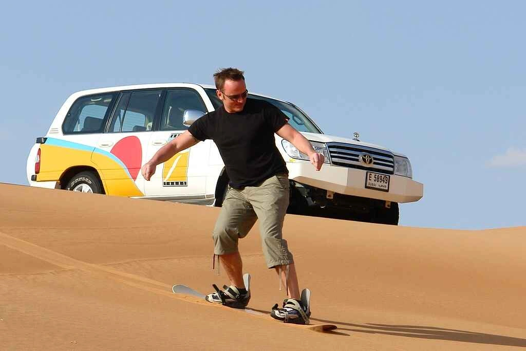 التزلق على الكثبان الرملية أثناء رحلات سفاري في الصحراء